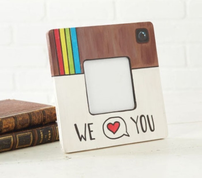 square frame, painted to look like the instagram logo, with the words we and you, divided by a speech bubble, containing a heart symbol