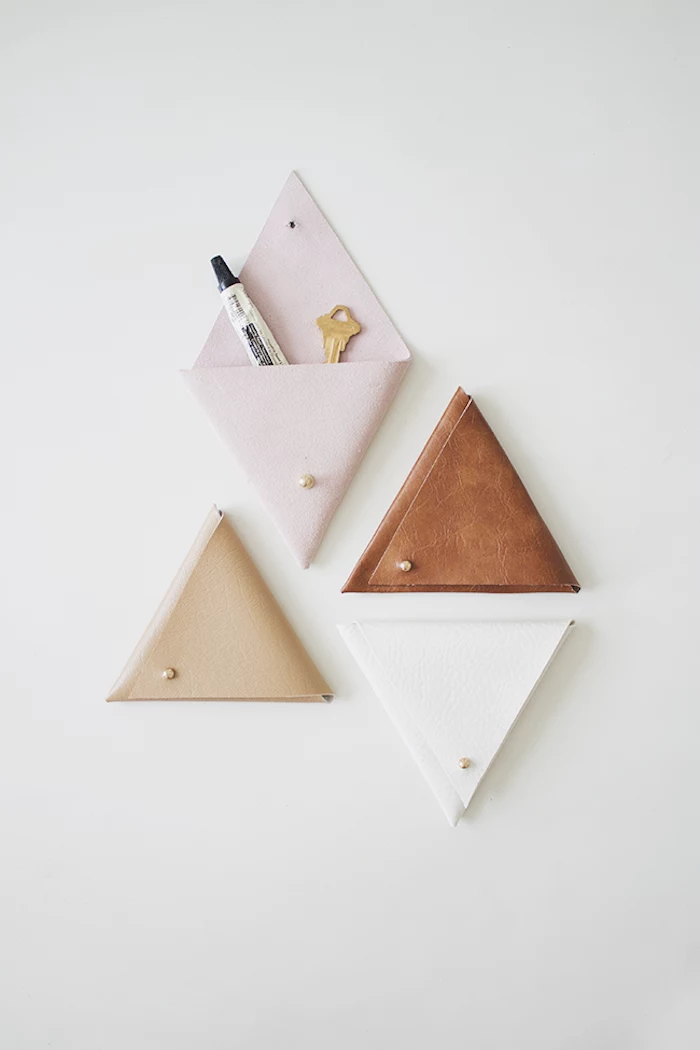 pink beige brown and white leather pouches, mounted on white wall, diy gifts for friends, wall organizers