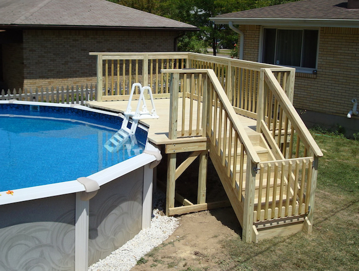 staircase and a small deck, made from pale, cream-colored wood, next to a garden pool, small above ground pools, houses in the background