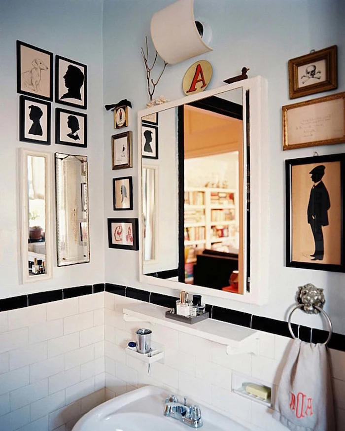 diy bathroom decor, lots of framed images, in different sizes, and one mirror, on the walls of a room, with a white ceramic sink