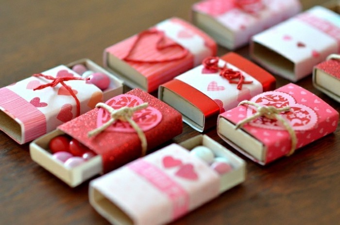 red and pink paper, with heart motifs, decorating several matchboxes, some opened to reveal white, pink adn red candies
