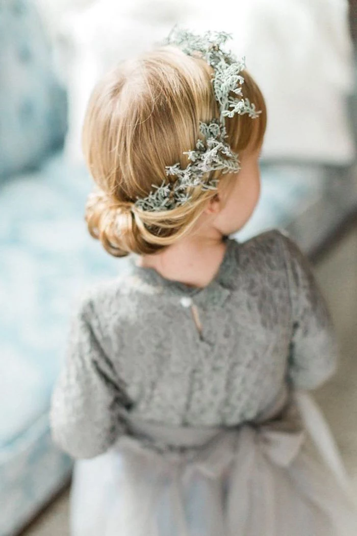 creamy grey formal dress, worn by a little blonde girl, with an up-do, simple hairstyles, braided around a moss-like, pale green wreath