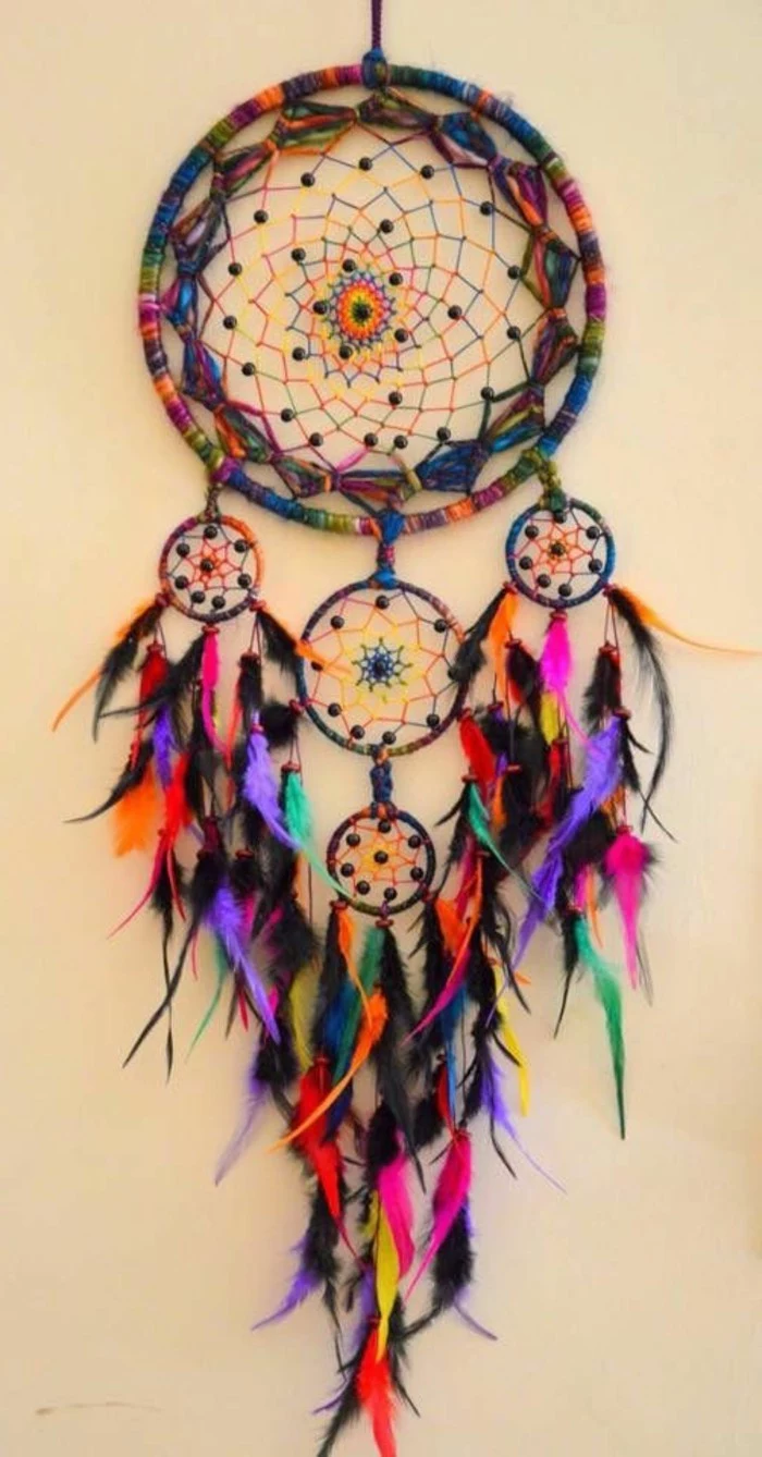 bright boho-style large dream catcher, with one big and four small, multicolored nets, featuring small feathers, in different colors
