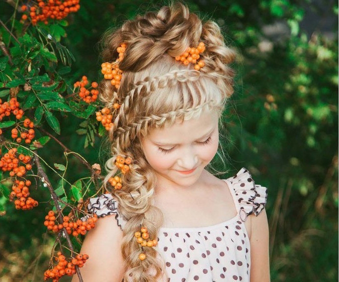 polka dot printed summer dress, worn by a smiling blonde girl, with two rows of braids, woven into one long plaid, kids hairstyles, messy curly bun, on top of her head