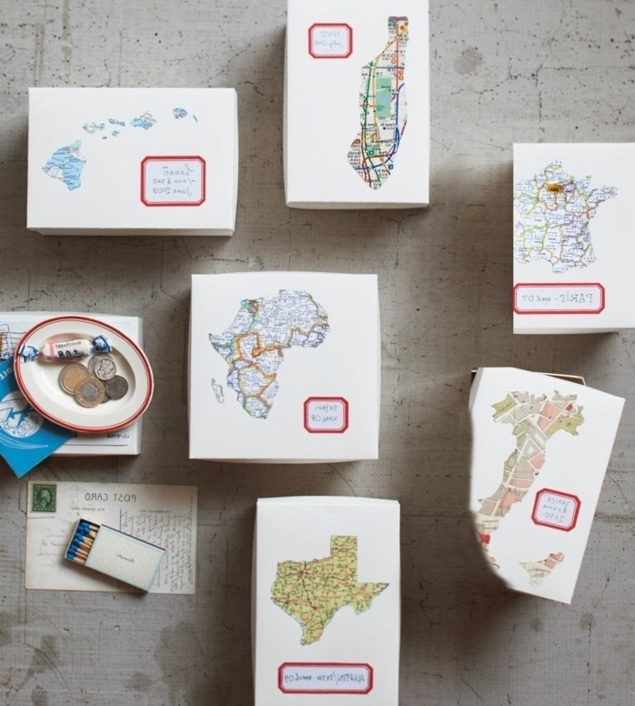six boxes made of card, each decorated with a different map, and a small, red-rimmed label, handmade gift ideas