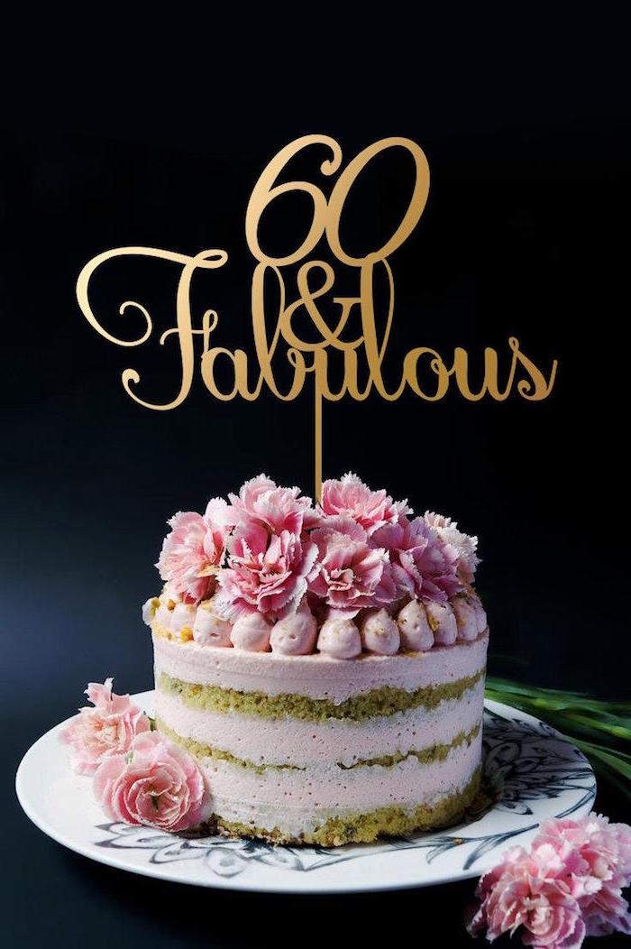 fresh pink flowers, on a creamy pale pink cake, decorated with a gold topper, bearing the inscription, 60 and fabulous