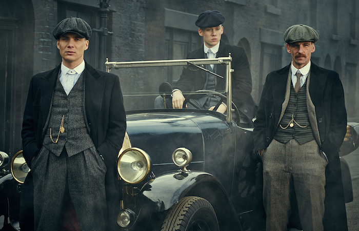 cillian murphy and two of his co-stars, dressed as 1920s british gangsters, standing in or next to an antique car, 20s mens fashion 