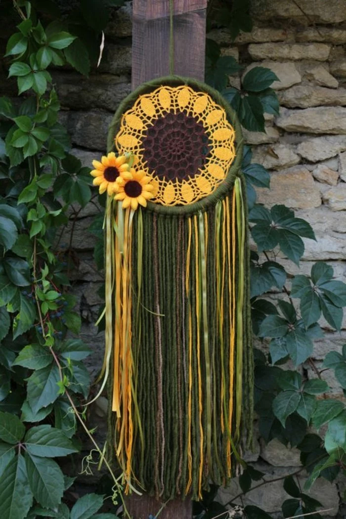 green and yellow dreamcatcher, with a crocheted doily, painted in yellow and brown, like a sunflower, green and yellow tassels