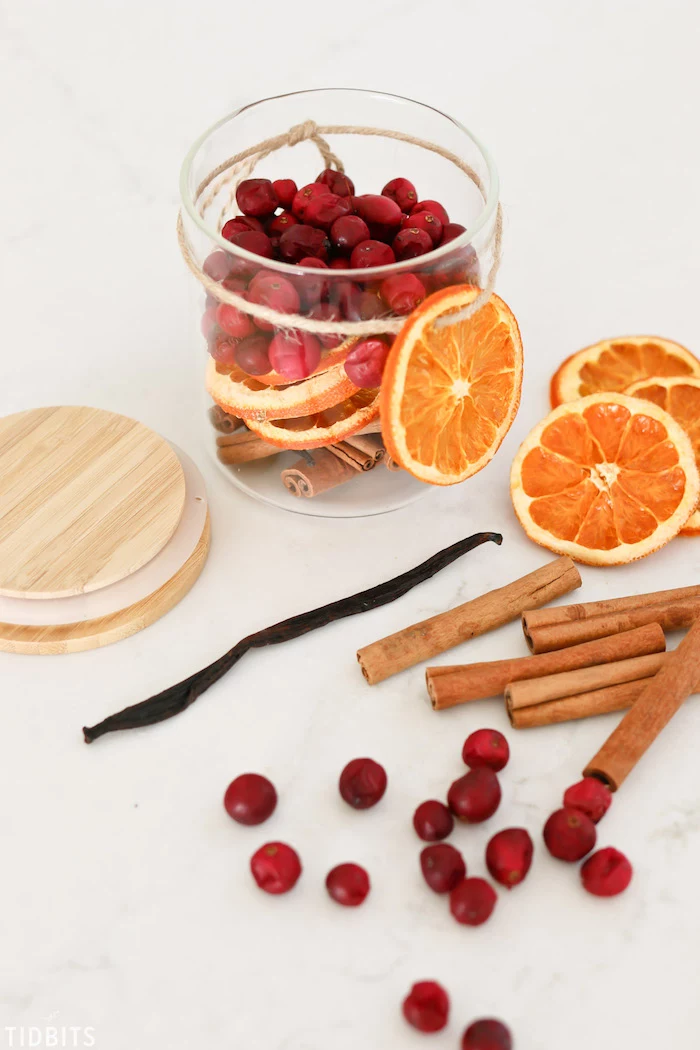 potpourri in a glass jar, made with dried orange slices and cranberries, cinnamon and vanilla sticks, diy christmas gifts