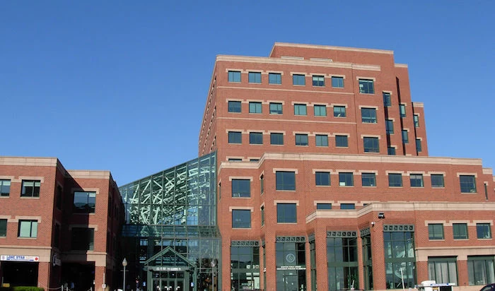 structure with rectangular shape, with multilayered effect, made from red and pale beige bricks, postmodernism examples, large glass details and many windows
