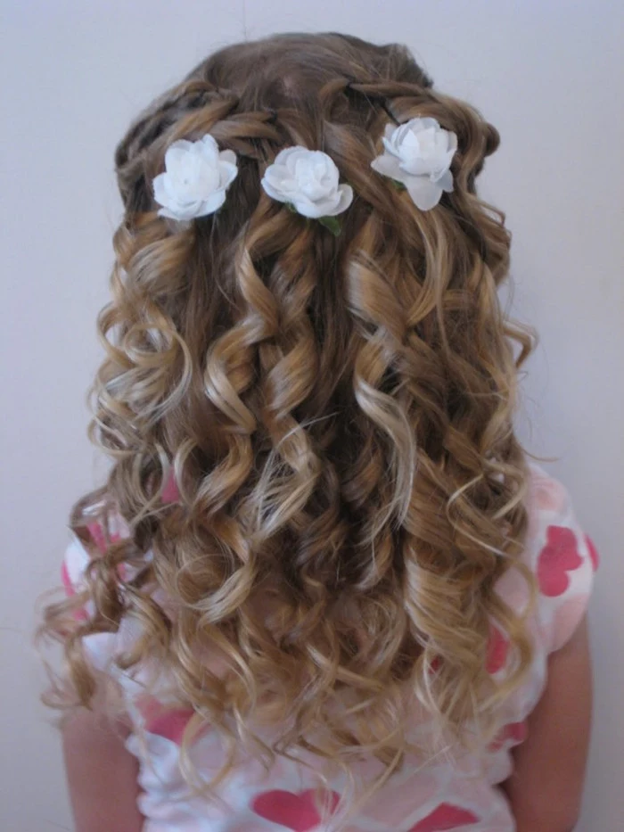 curled dark blonde hair, with strong natural highlights, and three white floral ornaments, simple hairstyles, seen from the back, worn by a small girl