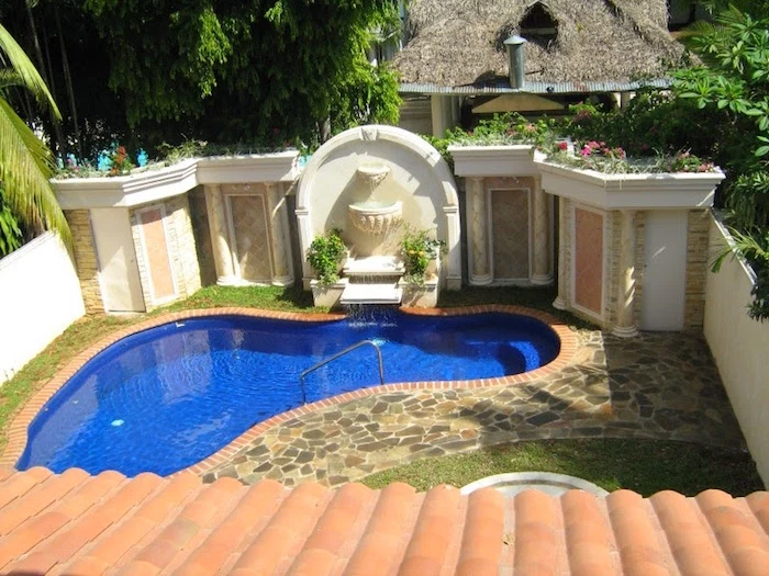 wall with columns and plaster details, decorated in ancient roman style, near a blue pool, in a small garden, small inground swimming pools, stone covered floor