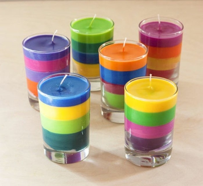 layered multicolored candles, inside six clear glasses, placed on a pale beige surface, last minute birthday gifts