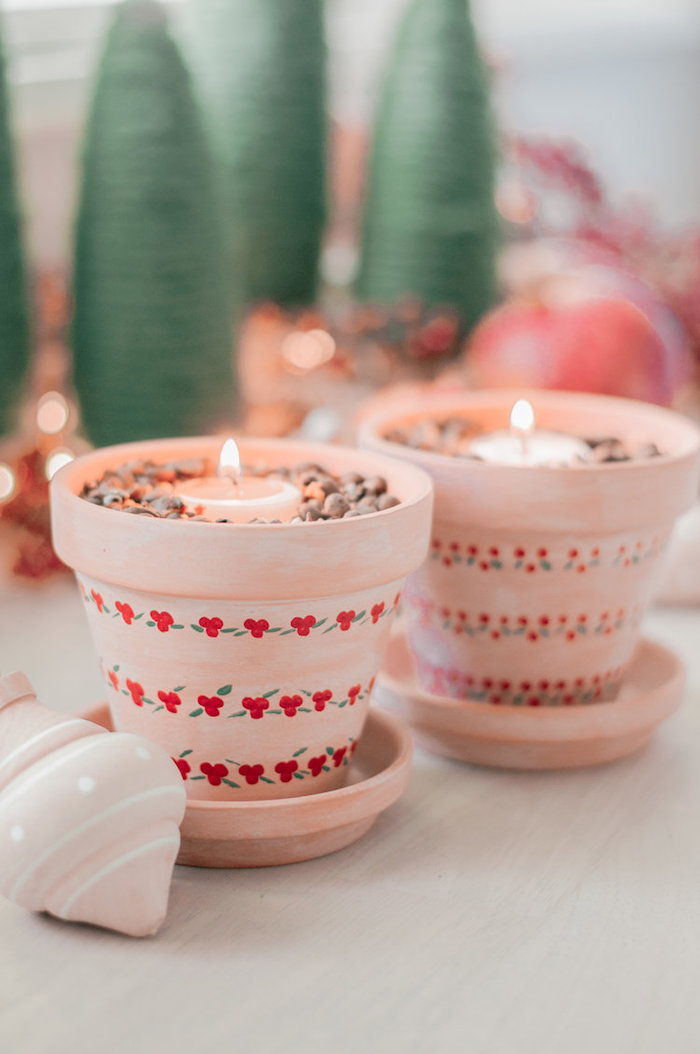 two ceramic pots, painted in pink with red flowers, best friend gifts diy, rocks and candles inside, placed on wooden table