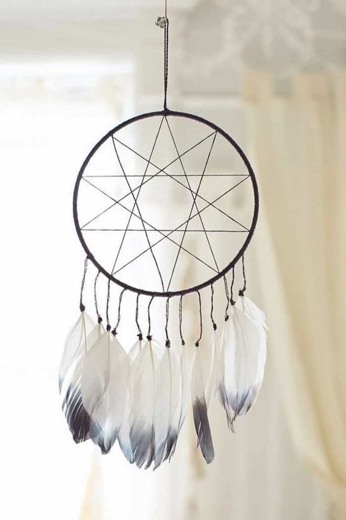 minimalistic dreamcatcher designs, star-like web motif, decorated with white feathers, with pale grey tips