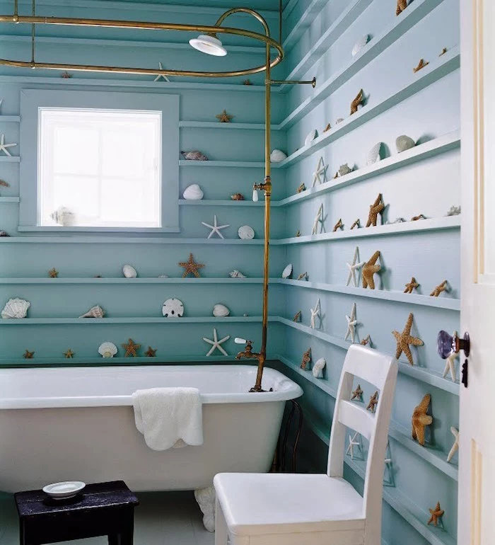 star-fish and different seashells, on shelves painted in pale turquoise, lining a wall in the same color, small bathroom décor, white bathtub and chair