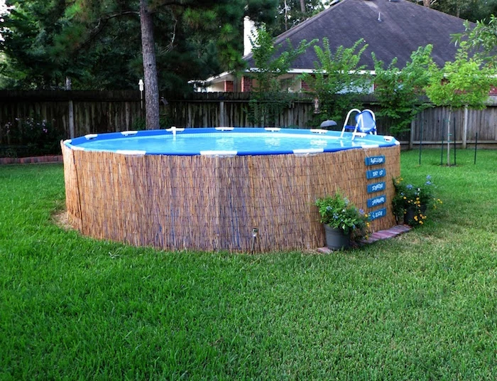 small above ground pools, straw-like material, lining a tall round pool, built on a green lawn, and decorated with two flower pots