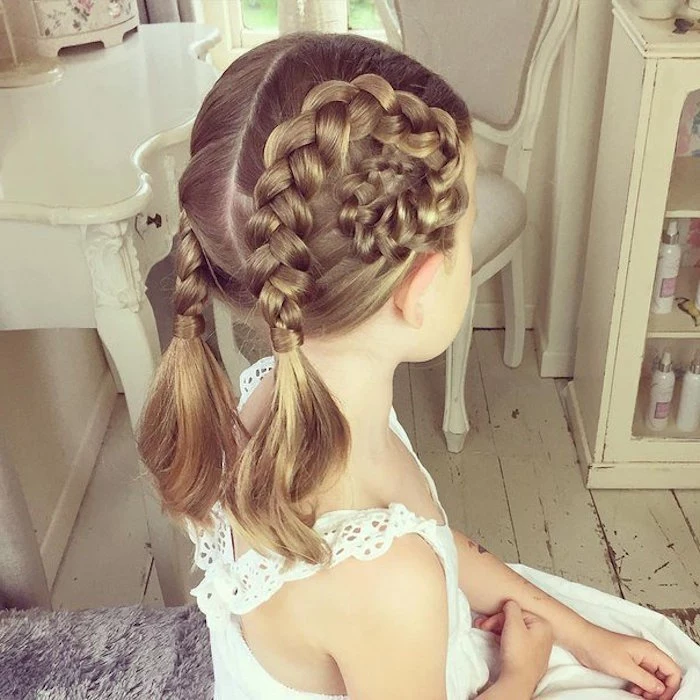 broderie anglaise summer dress in white, worn by a small child, with blonde hair, styled into braided, swirled pigtails