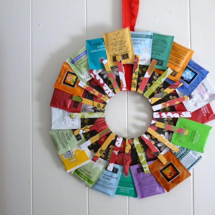 wreath made of tea packets, in different colors, secured with patterned clothes pegs, handmade gift ideas, mounted on a white wall