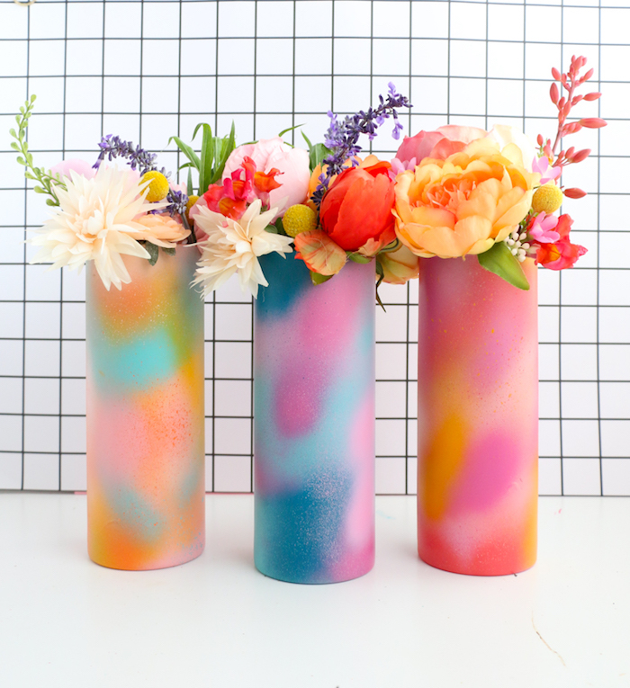 multicolored spray painted vases, placed on white surface, flower bouquets inside, thoughtful christmas gifts