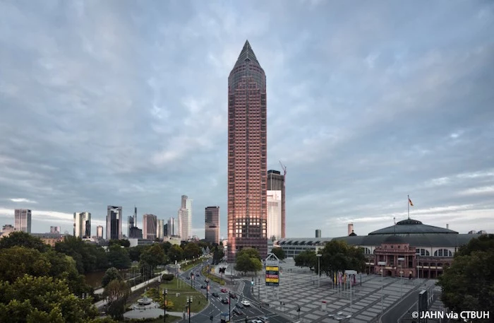 pencil-shaped brown tower-like skyscraper, in the middle of a city square, messeturm in frankfurt 