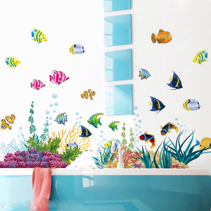 decal stickers featuring tropical fish, in many different colors, and seaweed and corals, on a white wall, near a teal and white bathtub, and four matching square glossy teal decorations, small bathroom decorating ideas