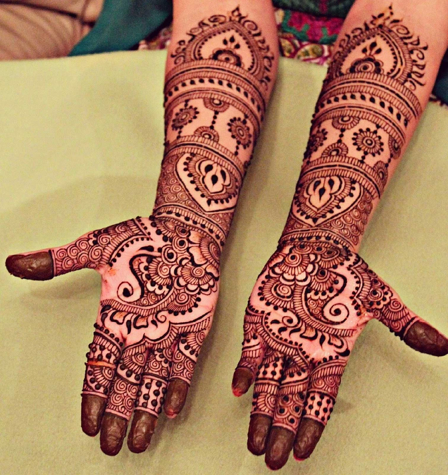newly applied brown henna, covering the palms, and forearms of a woman, traditional and cute henna designs