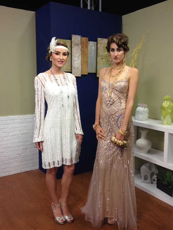 beads and silver embroidery, on a nude pink maxi dress, worn with lots of jewelry, by a brunette woman, standing next to a woman, in a white gatsby dress, with lace and embroidery