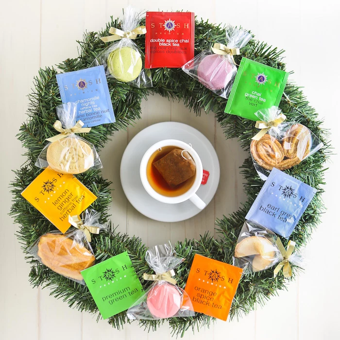 wreath made with tea bags and cookies, teacup in the middle, placed on white wooden surface, creative homemade gifts