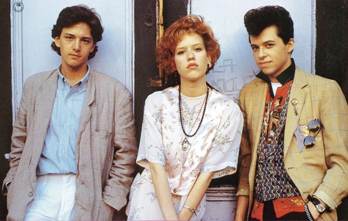 red-haired actress, with short curly hair, and two young men, dressed in vintage clothes, and sporting retro hairstyles, 80s costumes men, oversized jacket and multicolored patterned shirt, lots of accessories