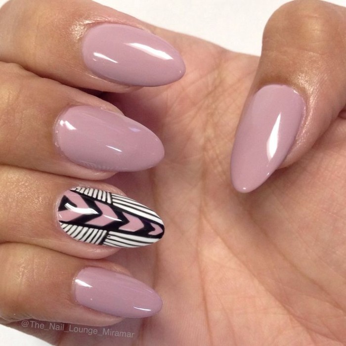 hand-painted decorations in white, black and pink, on the ring finger nail of a hand, with ash pink manicure, almond nail designs 