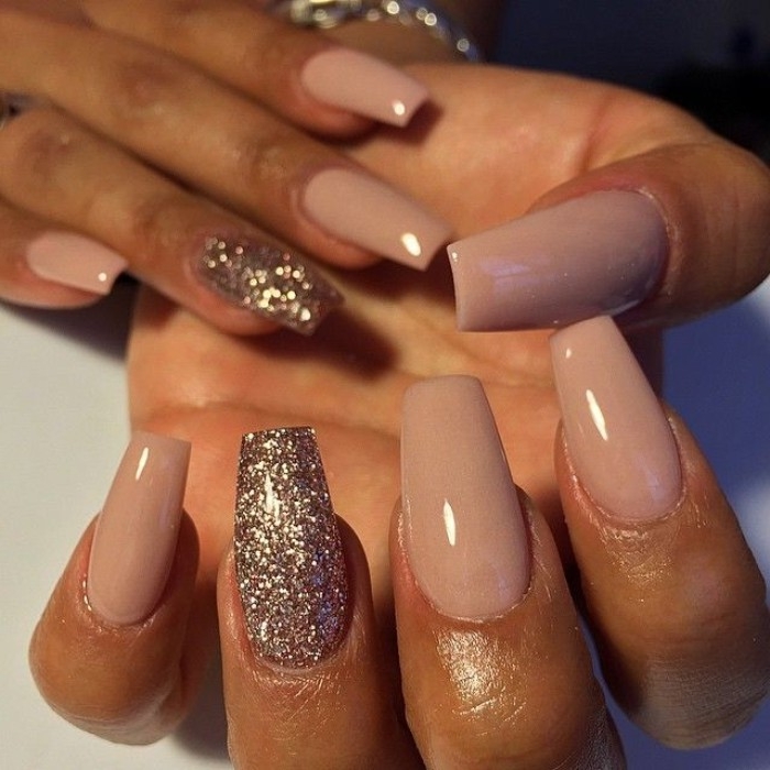 smoky pastel pink nail polish, on coffin shaped manicure, decorated with rose gold glitter, nude gel nails, on two brown hands