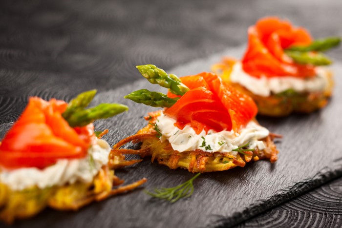 smoked salmon fillets, wrapped around asparagus tips, hor d oeuvres, on top of a cracker, with a creamy spread