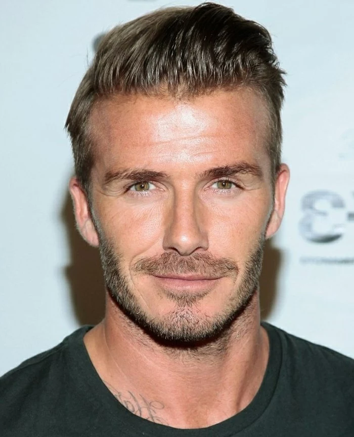 another photo of david beckham, with short slicked, back brunette hair, trendy haircuts for men, smiling in a black t-shirt