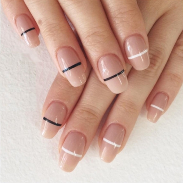 pink nude nails, with an oval shape, each decorated with a white, or a black stripe