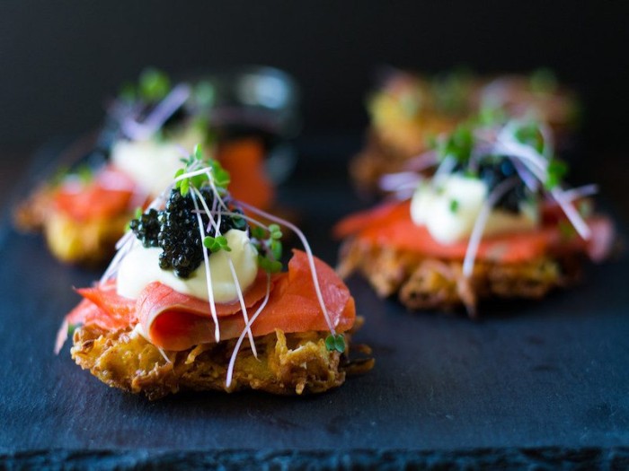 crispy crackers topped with smoked salmon fillets, mayo and black caviar, hors dourves with watercress on top