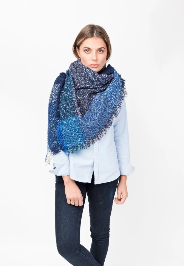 navy and bright blue oversized shaw, wrapped around the shulders of a slim, young brunette woman, how to wear a square scarf, with jeans and a pale shirt