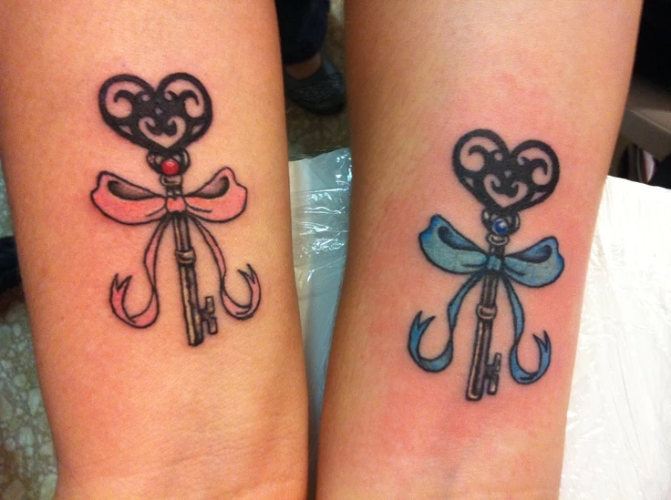 baby pink and baby blue bows, tied around vintage, heart-shaped ornate keys, matching sister tattoos, on two wrists