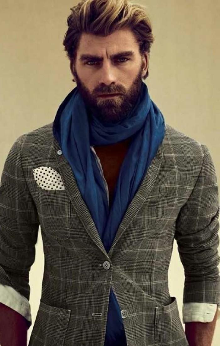 fitted grey checkered suit, worn with a white shirt, and a long blue scarf, by a bearded man, with an ombre-effect quiff, modern haircuts for men