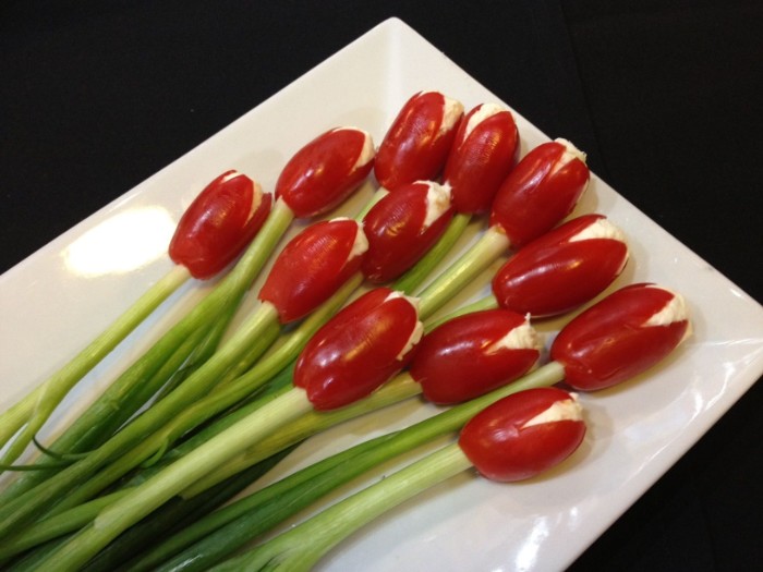 tullips made from oval cherry tomatoes, stuffed with cream cheese, and attached to sprigs of spring onion, hour derves for creative cooks 