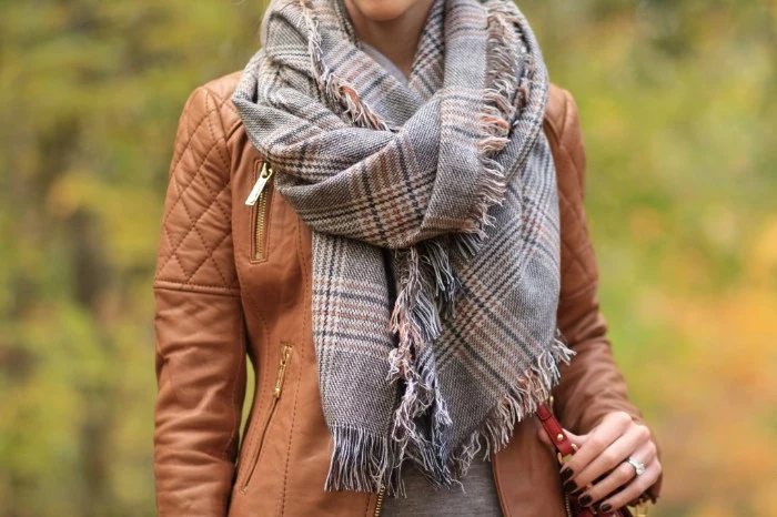how to wear a square scarf, in light grey, with a plaid pattern, over a brown leather jacket