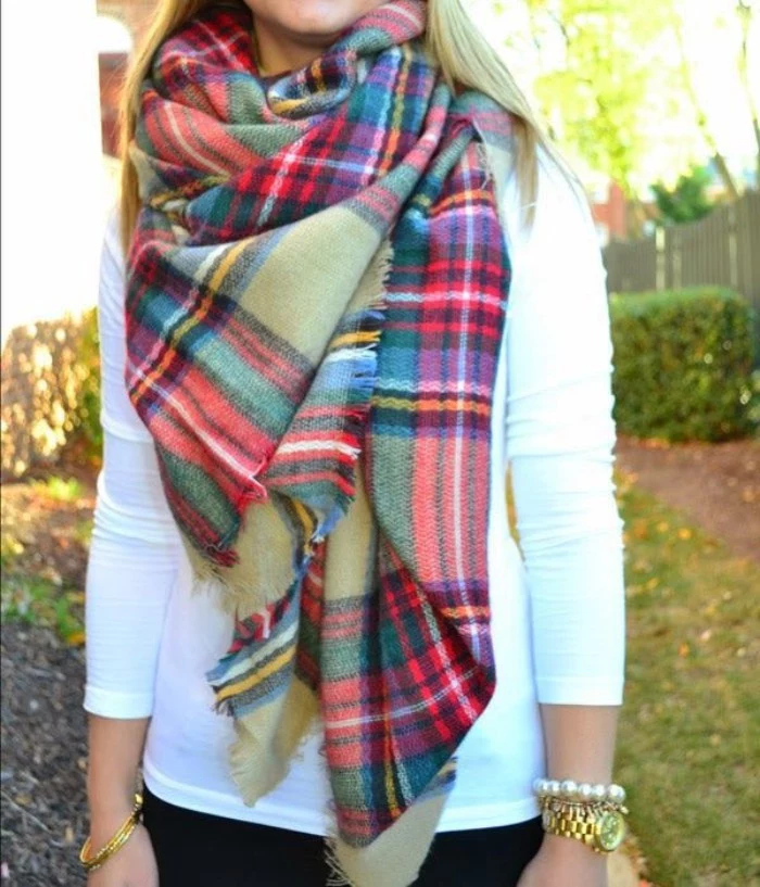 yellow and white, black and green, red and blue stripes, on a pale kahki green tartan scarf, worn over a white jumper, how to wrap a blanket scarf