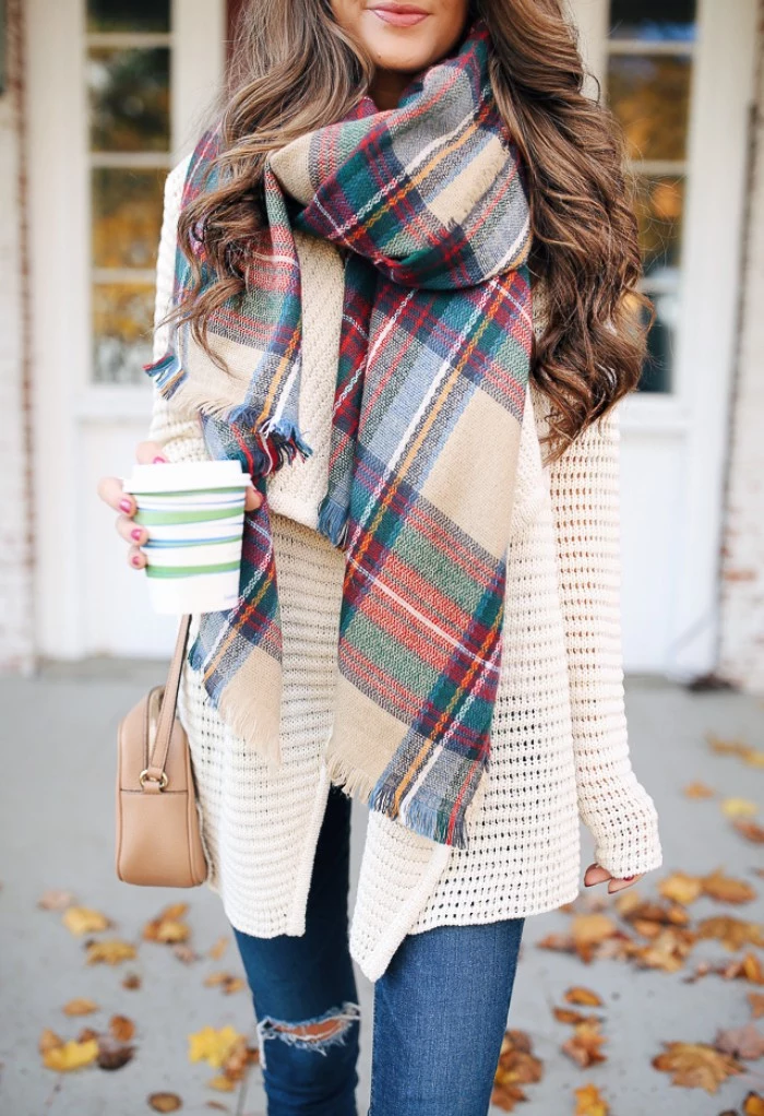 beige and red, green and blue, grey and white plaid scarf, worn with an off-white knitted cardigan, and distressed skinny jeans, how to tie a blanket scarf, by a smiling brunette woman