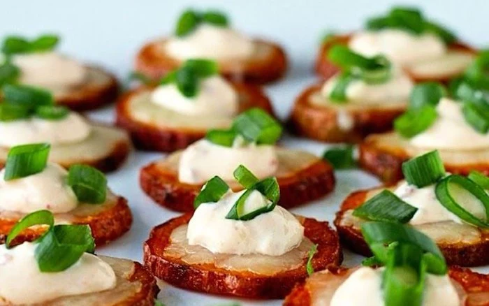 chopped green onions, on top of potato slices, roasted with their skins, and garnished with creme fraiche