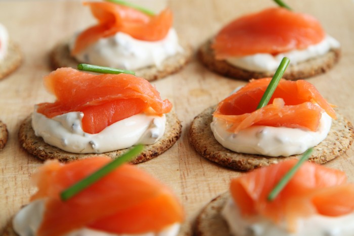 cream cheese and smoked salmon, on flat crackers, with creamy white spread, hors dourves topped with chives