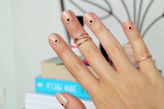 points in black, on a short and square manicure, painted with a glossy, nude pink nail polish