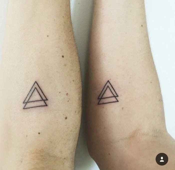 simple and minimalistic tattoos, of two double triangles, done with black ink, under the crrok of two elbows