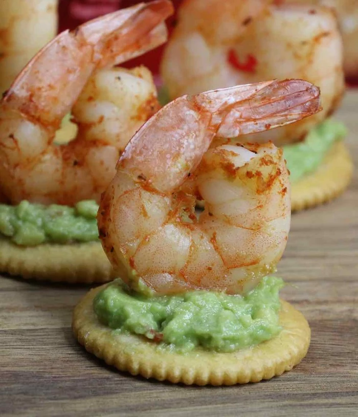 hor dourves, grilled seasoned prawns, topping several ritz crackers, with a mushy, green avocado spread