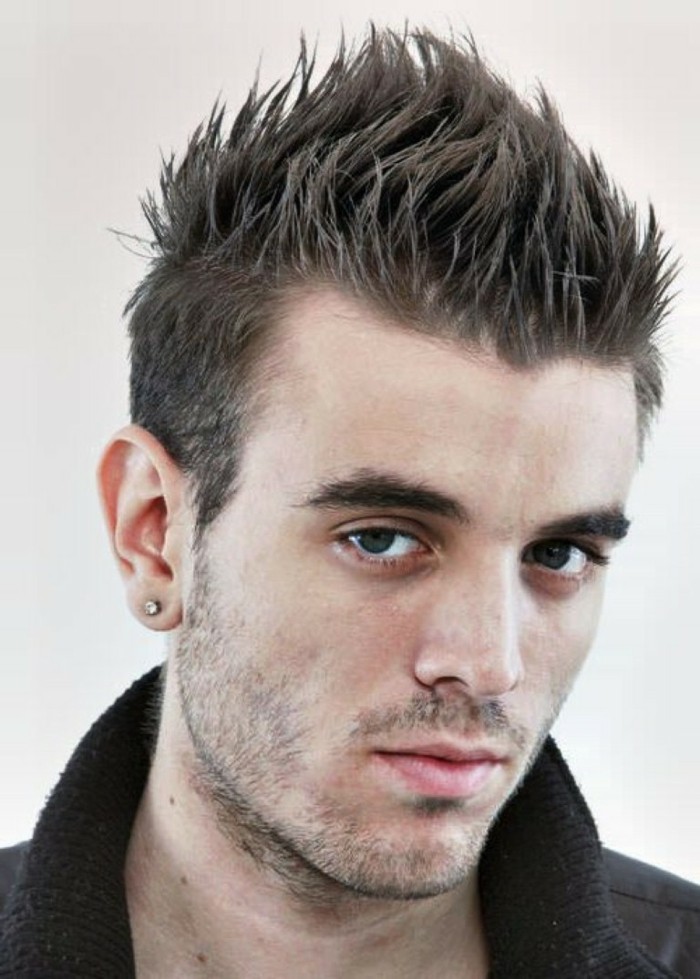 spiky faux hawk, worn by a young man, with a diamante stud earring, and stubble on his jaw and upper lip