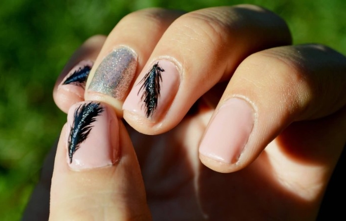 black feathers painted on short, square pink nails, decorated with silver glitter, best nude nail polish